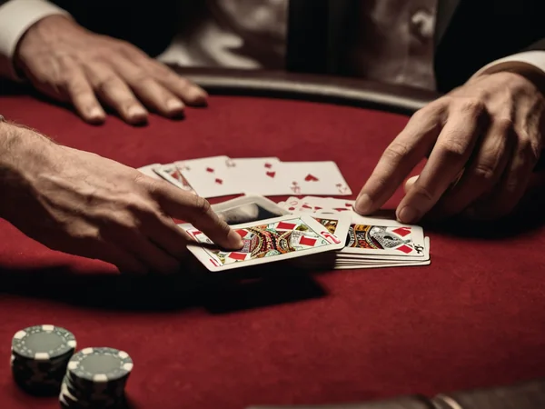 Dealer laying cards to the left and right piles of an Andar Bahar table